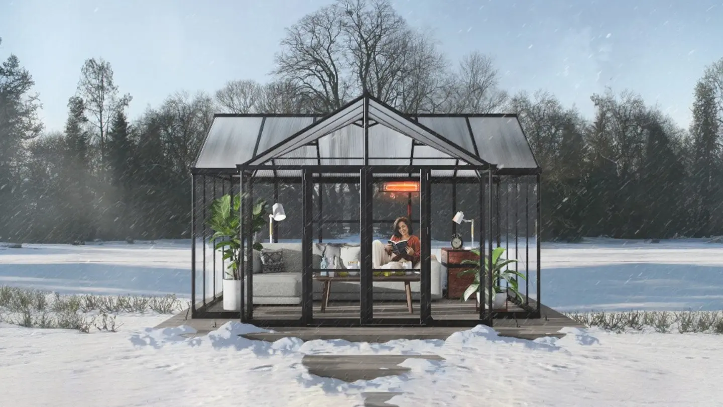 Serra da giardino a forma di T in alluminio nera in un giardino con neve